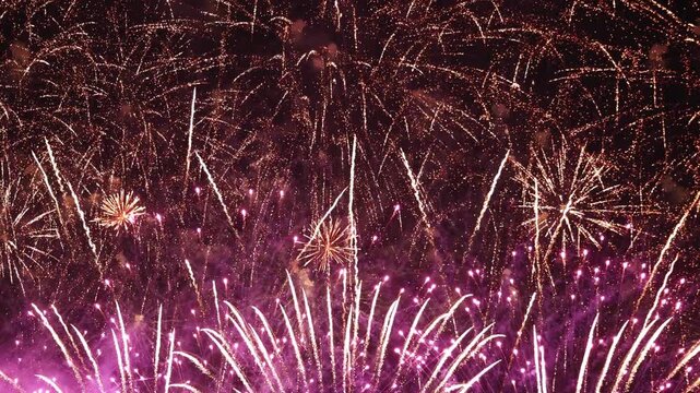 Bright golden and purple fireworks exploding in dark night sky, representing grand celebration, New Year event, anniversary party, festival, Independence Day, and holiday background concept