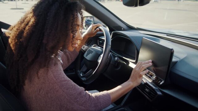 Woman explores touchscreen controls inside modern new car