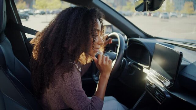 Woman uses dashboard touchscreen while sitting in new car