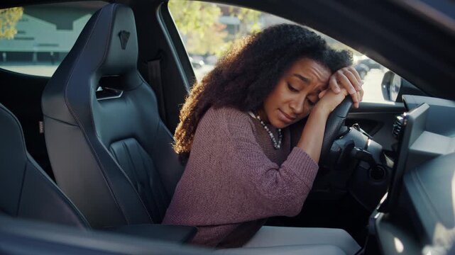 Exhausted woman leans on steering wheel during quiet travel break