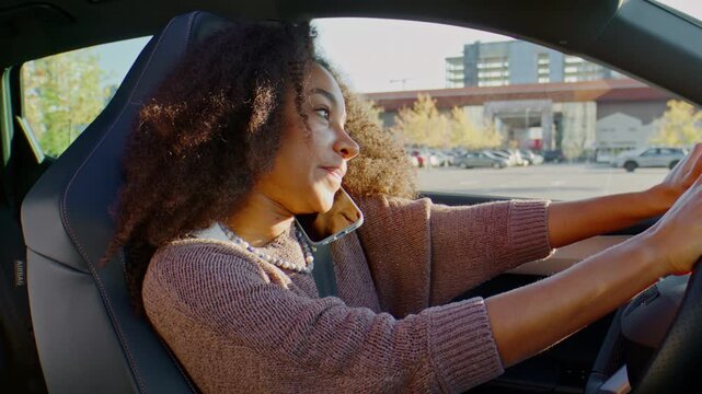 Woman talks on smartphone while driving car through city road