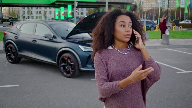 African American woman speaks on smartphone to car repair service
