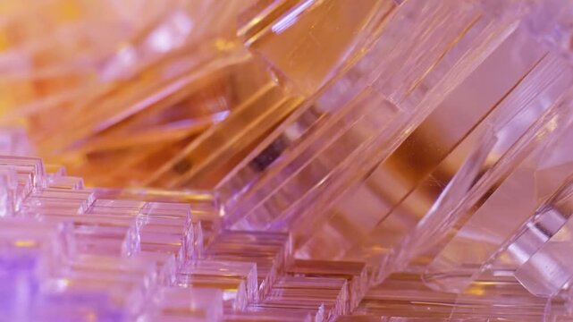 Translucent crystal blocks form a layered abstract pattern in purple and gold