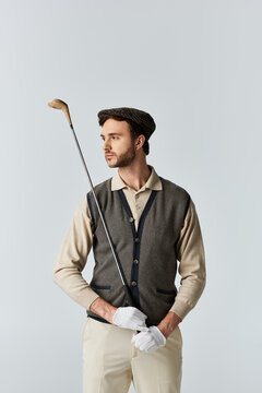 A bearded golfer poses in a tweed vest and flat cap against a pale studio backdrop