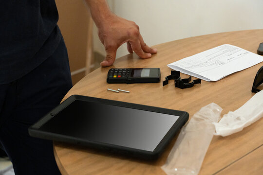 Worker standing at a table with a tablet and POS terminal