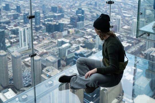 Person Sitting on Glass Ledge, Chicago Skyline