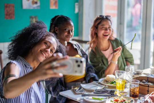 Young women take selfies during lunch in a restaurant