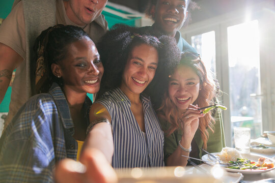 Friends take selfies at a restaurant.