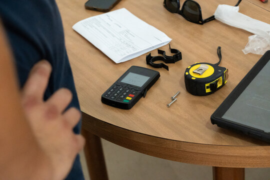 Handyman tools, tablet, and POS device on a round table