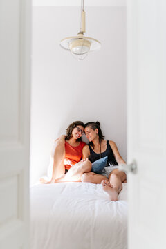 Lesbian couple sharing intimate moments in bedroom