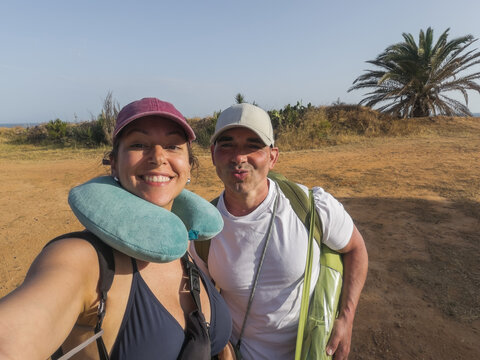 Happy couple taking selfie after a day at the beach