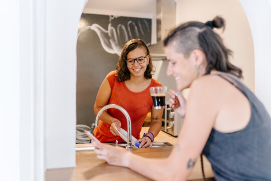 Lesbian couple doing morning chores and enjoying coffee