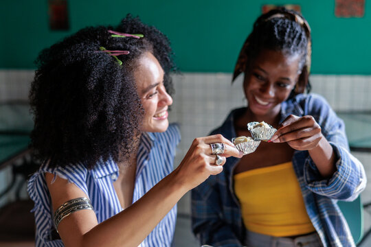 Smiling women toasts with dim sum