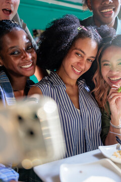 Friends take selfies at a restaurant.