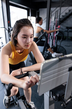 Woman sets program on a stationary bike