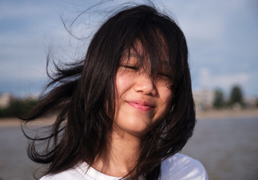 Portrait of a Chinese girl enjoying the sea breeze at the beach