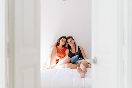 Lesbian couple relaxing together in bedroom