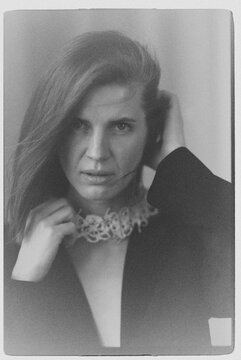 A film portrait of a woman wearing a jacket and pearl jewelry