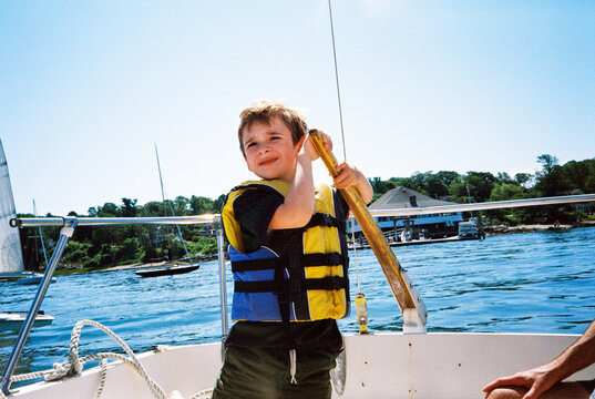 Confident young child learning how to sail