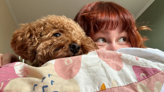 Morning mischief with a red-haired woman and her puppy