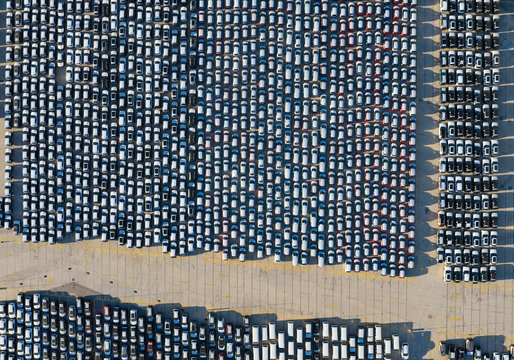 Aerial view showing thousands of new cars parked in a massive lot