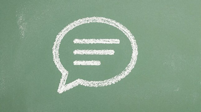 White chalk speech bubble icon drawn on green chalkboard background. Simple message symbol with text lines represents chat, conversation, communication concept. Minimalist hand drawn doodle for