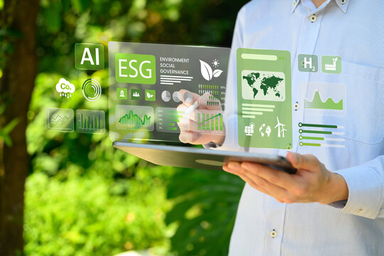 Businessman Analyzing ESG Investment Strategy on Tablet with Holographic Data Dashboard Showing Environmental Social Governance Metrics