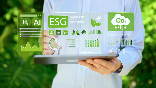 Businessman Analyzing ESG Environmental Social Governance Dashboard on Digital Tablet with Virtual Holographic Interface