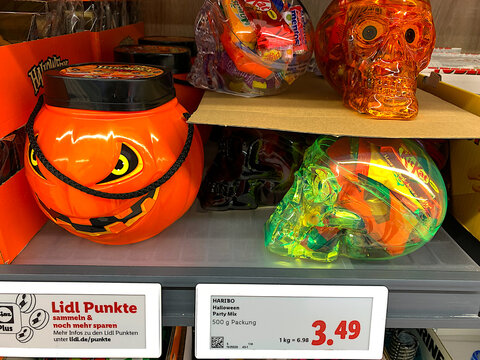 BAD WILDUNGEN, GERMANY &mdash; NOVEMBER 23, 2026: Halloween candy buckets shaped like a pumpkin and skulls filled with branded sweets displayed on a supermarket shelf at Lidl.