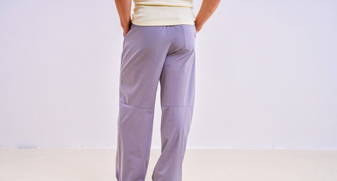                               Asian athletic male model in light purple loose casual trousers, studio apparel photo on plain background 