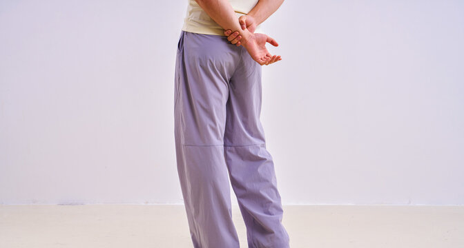                               Asian athletic male model in light purple loose casual trousers, studio apparel photo on plain background 