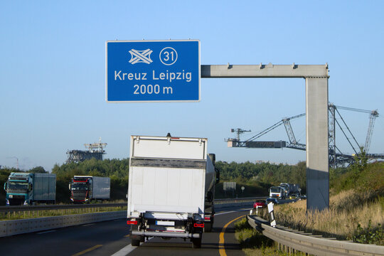 Autobahnkreuz Leipzig-S&uuml;d (Nummer 31) auf der Bundesautobahn 38 in 2000 Metern Entfernung und Tagebaubagger im Hintergrund.