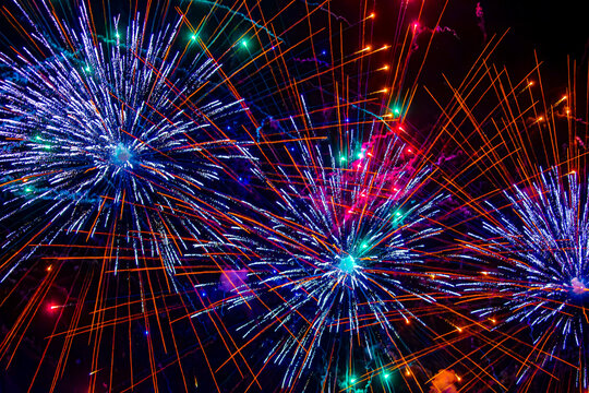 Fireworks close-up. Multicolored fireworks in the night sky, bright festive background with space for text.