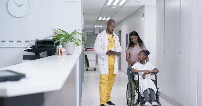 African American doctor with steth checking tablet, carer pushing child wheelchair discussing care