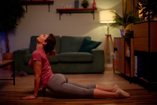 Gentle stretch with calm breathing. Woman positions for safe backbend exercise. Wellness instructor demonstrating soft back stretch emphasizing breath and spinal extension