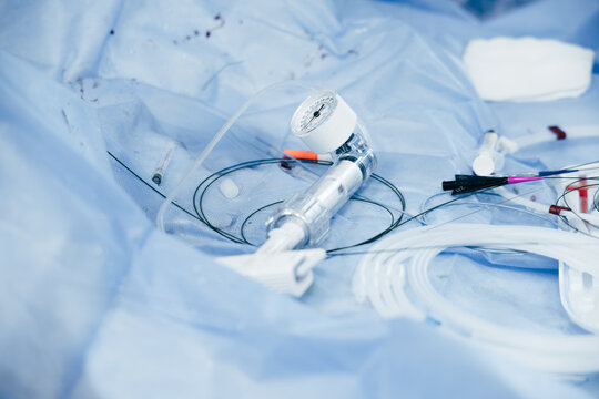 Close-up of a PTCA balloon inflation device (indeflator) on a sterile surgical drape during coronary angioplasty, used for controlled balloon catheter inflation. Medical equipment and healthcare.
