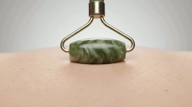 Gentle jade facial roller gliding over smooth skin