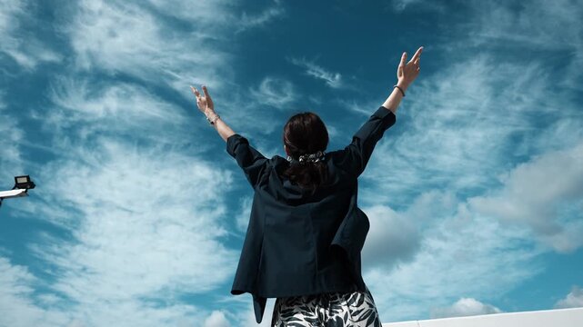 Person Raising Arms Toward Blue Sky in Celebration and Freedom, Slow Motion
