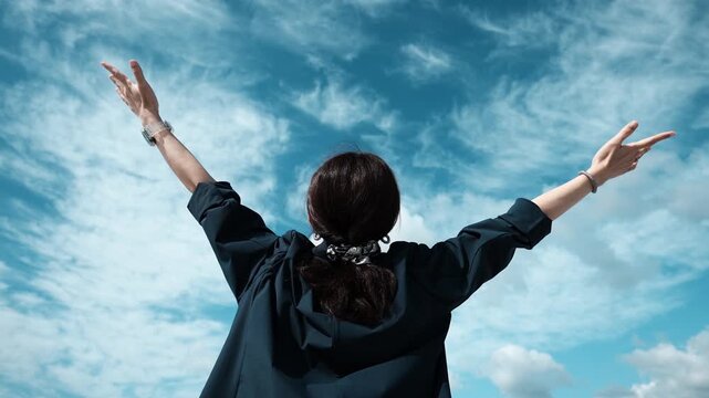 Person Raising Arms Toward Blue Sky in Celebration and Freedom, Slow Motion