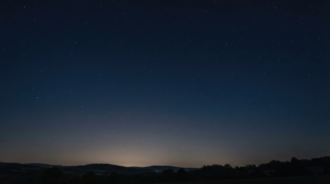 A dark night sky is filled with countless stars and a faint, luminous horizon.