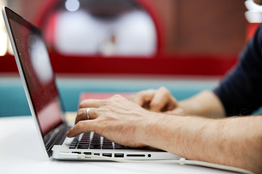 Hands typing on laptop keyboard.