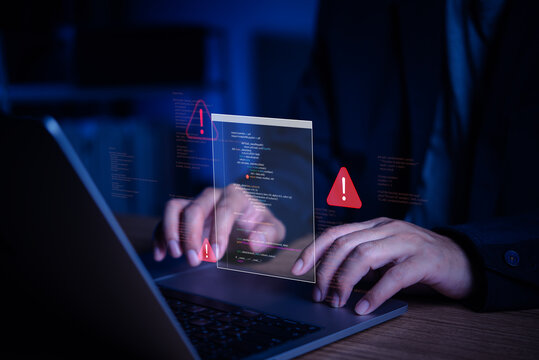 Cybersecurity and software developer debugging code on laptop with red error warning alerts, programming interface and dark workspace.
