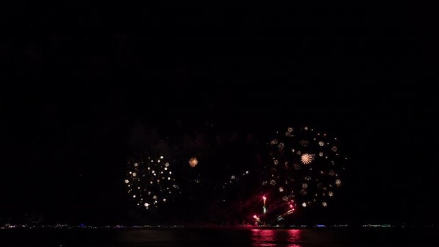 Vibrant Red And Golden Fireworks Exploding Over The Dark Ocean Water During An International Festival In Pattaya Chon Buri Thailand At Night
