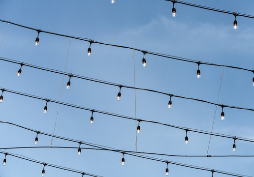USA, WA, Levenworth.  Strings of lightbulbs over an outdoor restaurant patio.