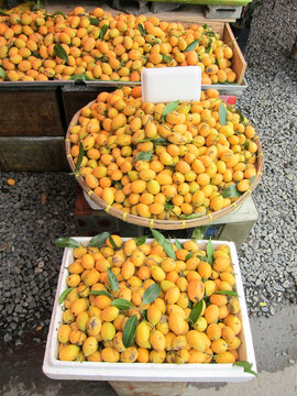 ipe yellow marian plums displayed in baskets at a fresh fruit market stall