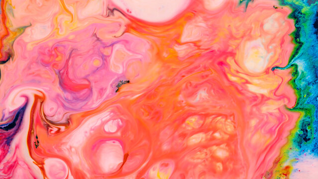Pink and coral fluid art background with swirling liquid paints and turquoise edges
