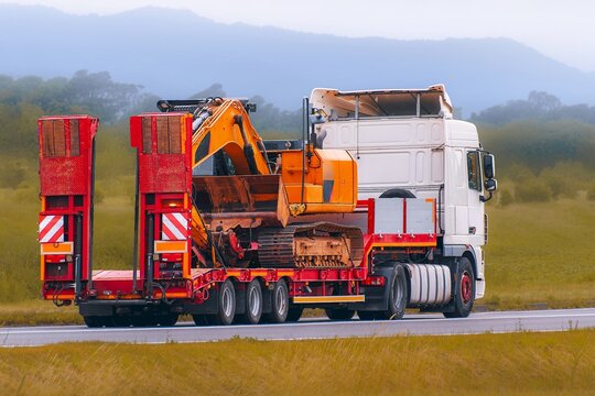 Flatbed trailers moving heavy construction vehicles