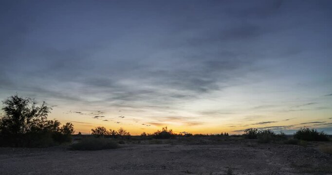 Time-lapse of sunrise over a vast Gobi wilderness, the sun rising above the horizon as golden light spreads across a dramatic sky.
