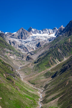 Panoramic view of glacial u-shaped valley having snow cladded peaks, glaciers and moraines  deposited by glacier in high altitude Himalayas mountain region of Himachal Pradesh, India.