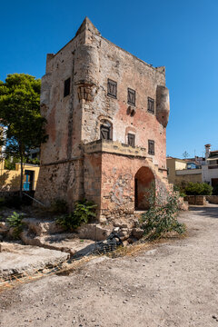 The historic Markellos Tower stands under a clear blue sky in Aegina Town, showcasing Venetian watchtower architecture and weather-worn stone masonry on Aegina Island, Greece